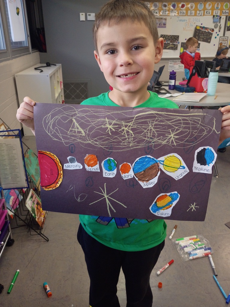 Student smiling with their solar system project. 