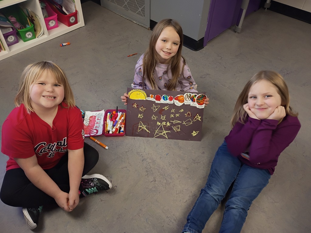 Students smiling with their solar system project. 