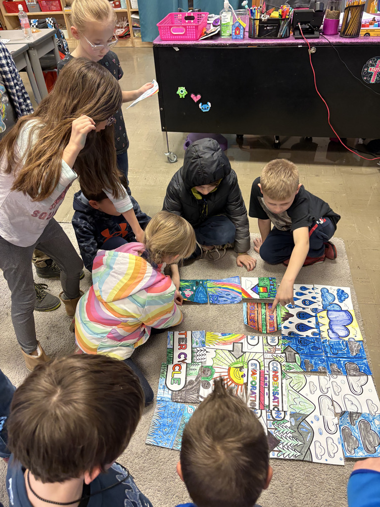 Students working on a collaborative water cycle poster.