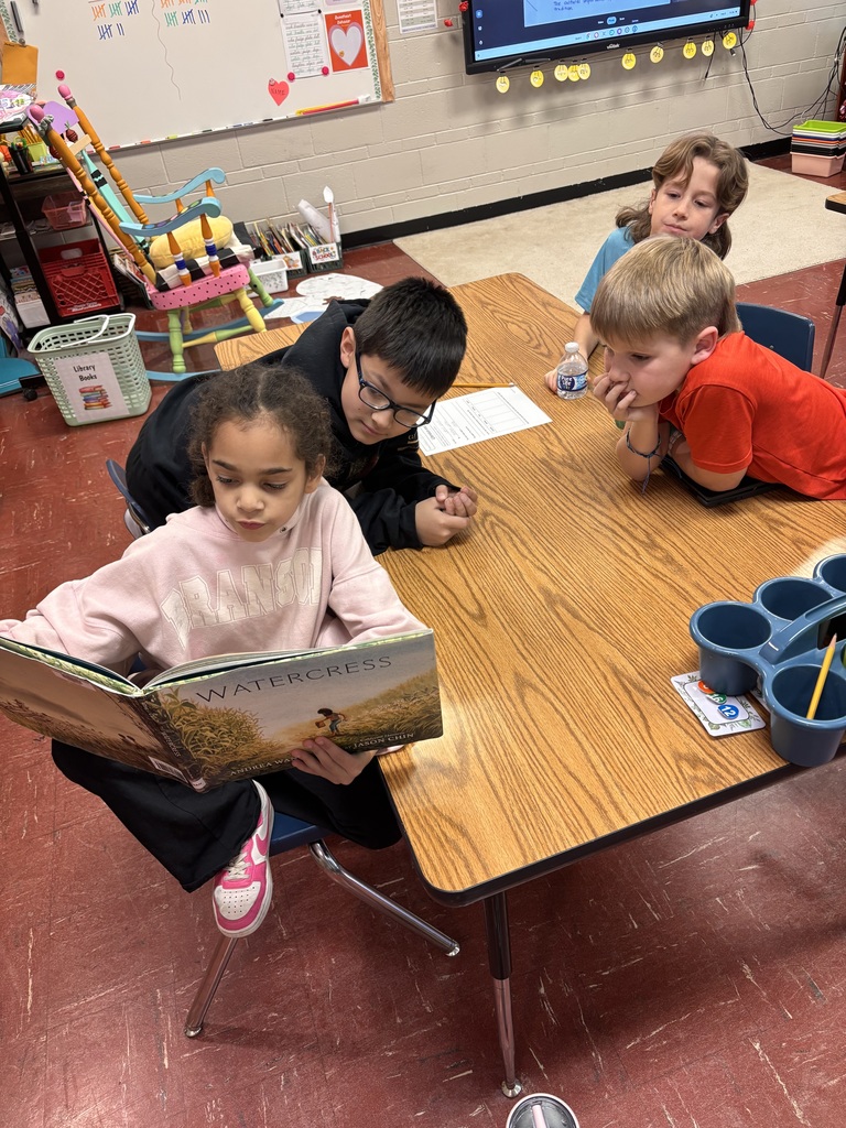 Students reading a picture book exploring different cultures.