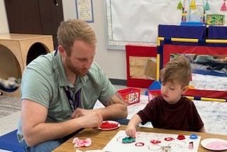 Paraprofessional working with a student.