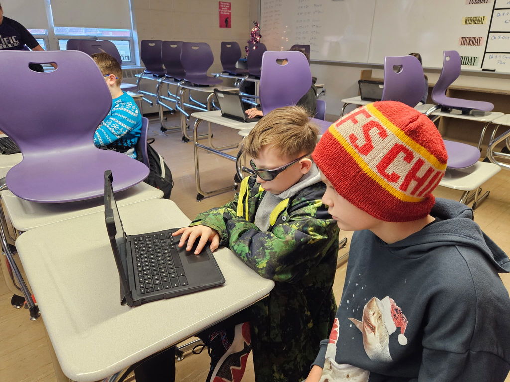 Students working on planning a trip presentation.