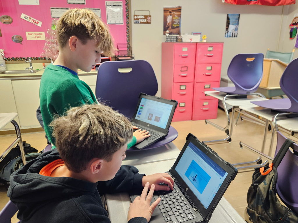 Students working on planning a trip presentation.