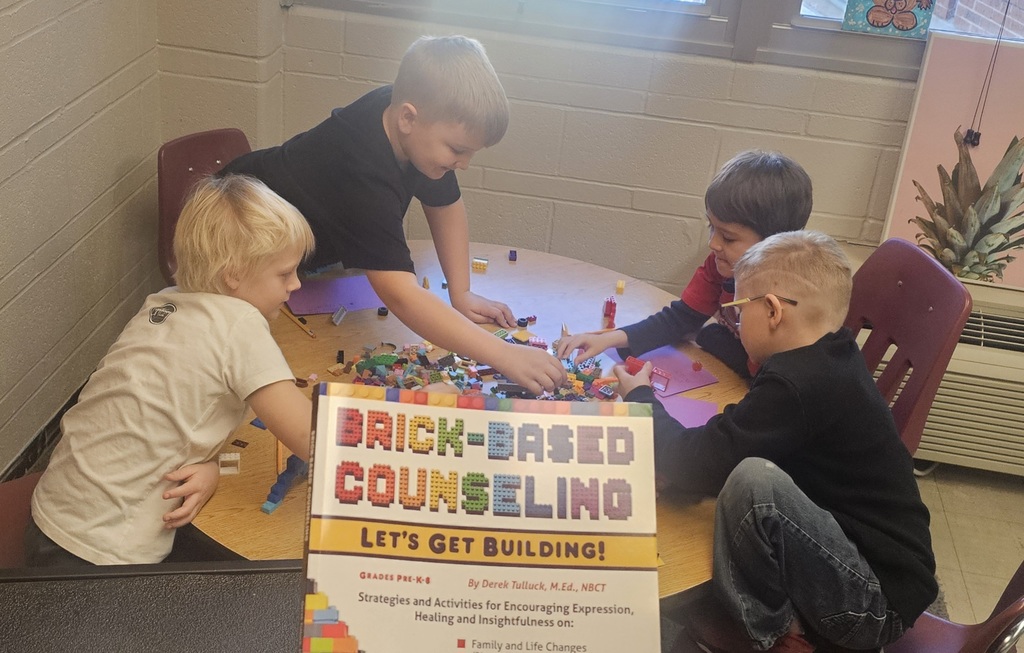 Students working on brick-based counseling at a group table.