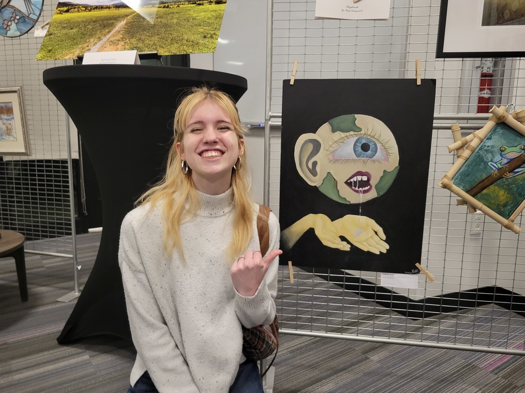 Student posing next to their art work.