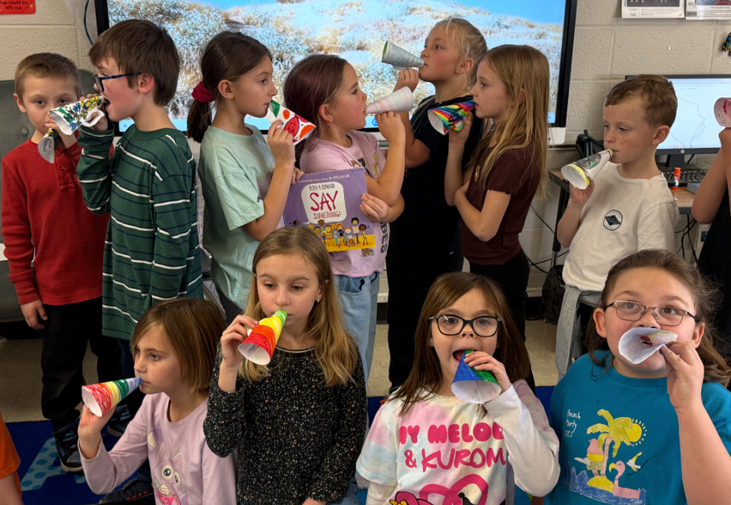 Students using paper megaphones that they drew on.