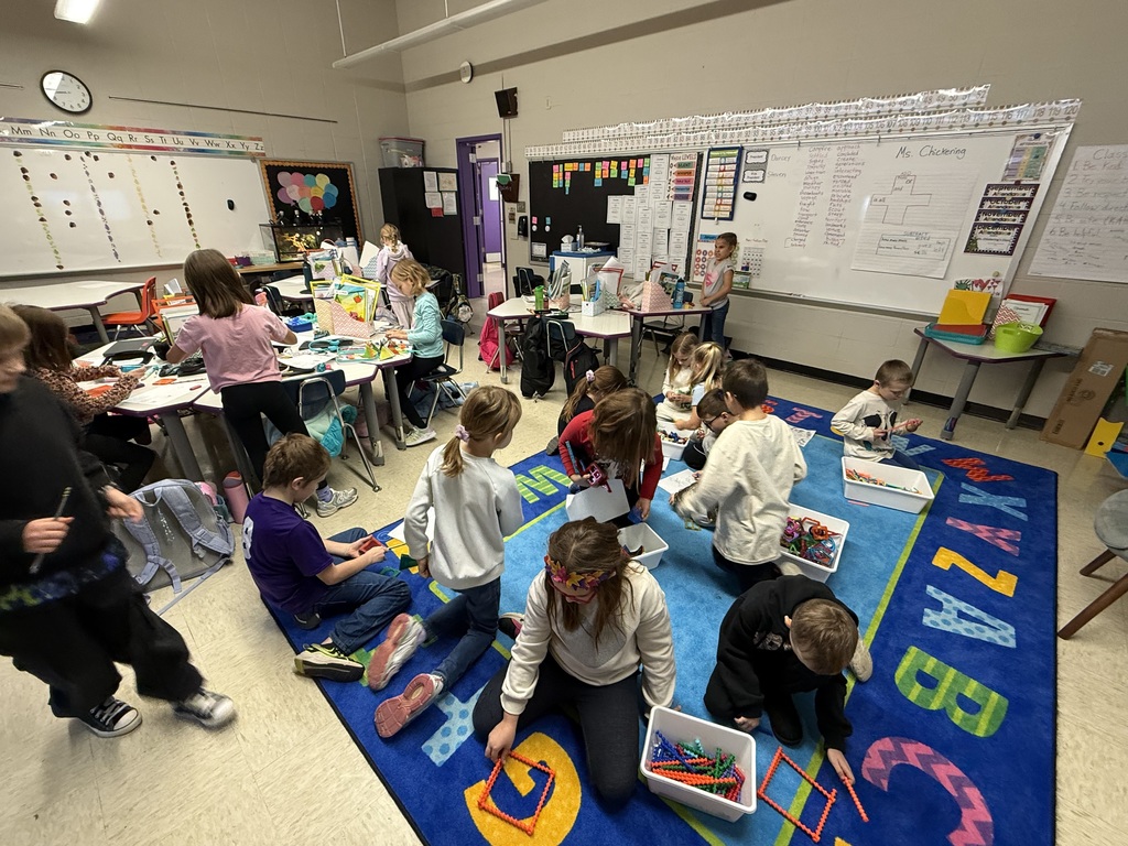 Students in a classroom building block statues.