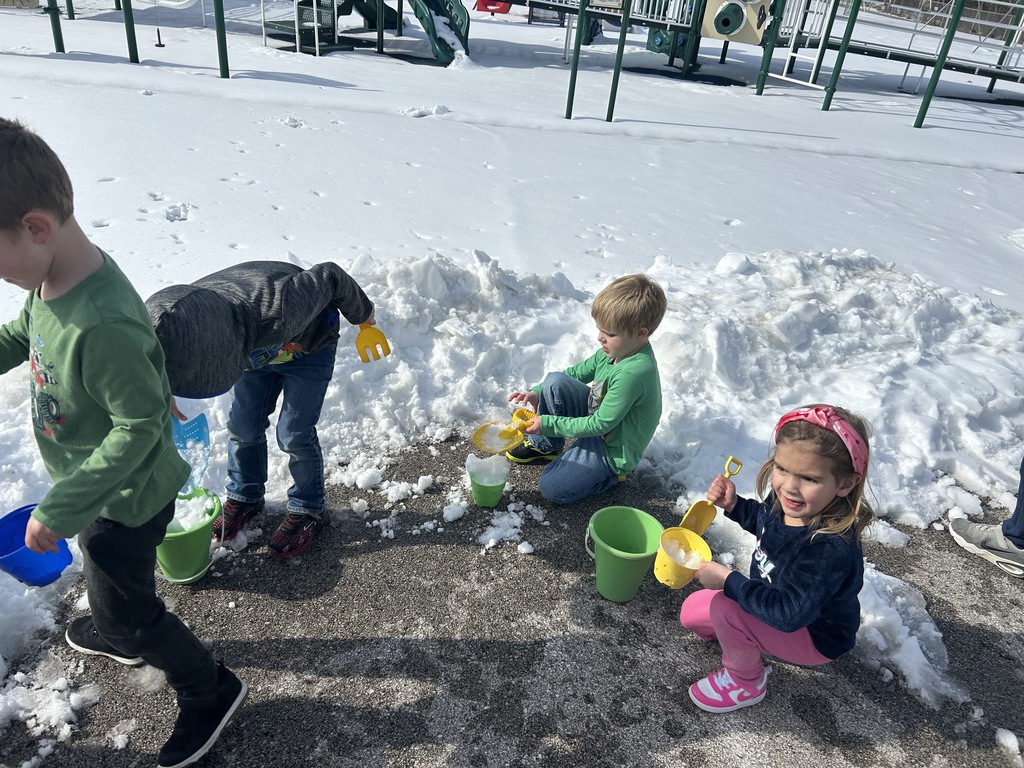Students shoveling snow into buckets.