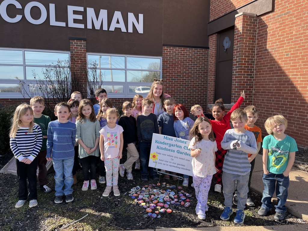 Elementary students group photo in front of Kindness Rock garden.