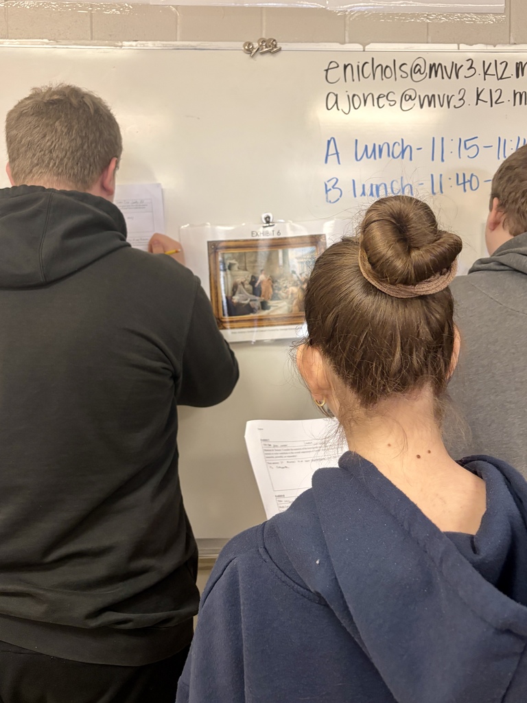 Students examining a piece of art in their fine arts gallery.