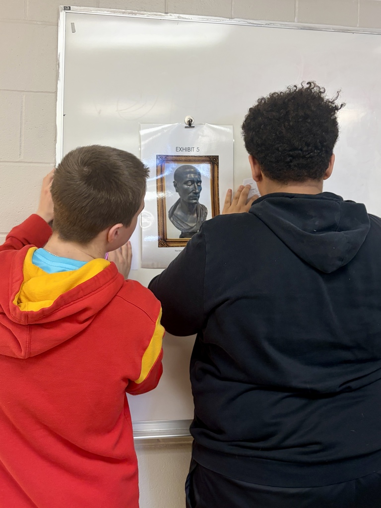 Students examining a piece of art in their fine arts gallery.