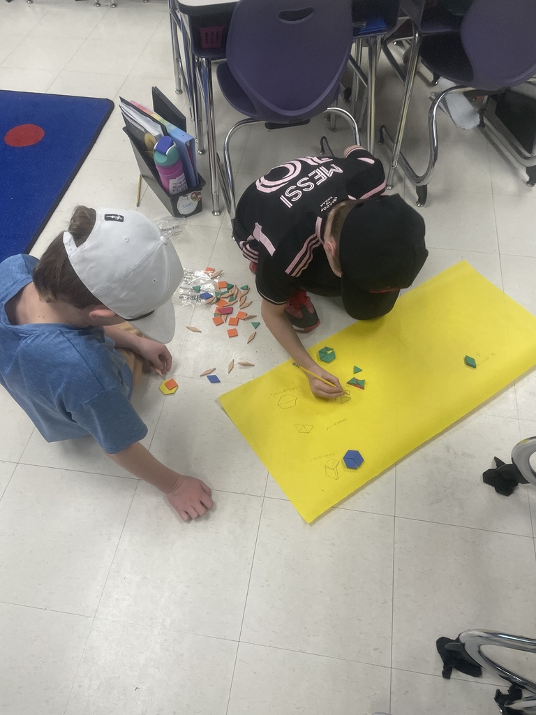 Students working with shape blocks in an activity. 