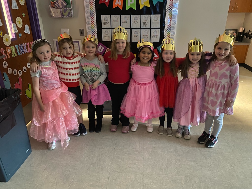 Students dressed up as Queens in all pink in an elementary classroom.