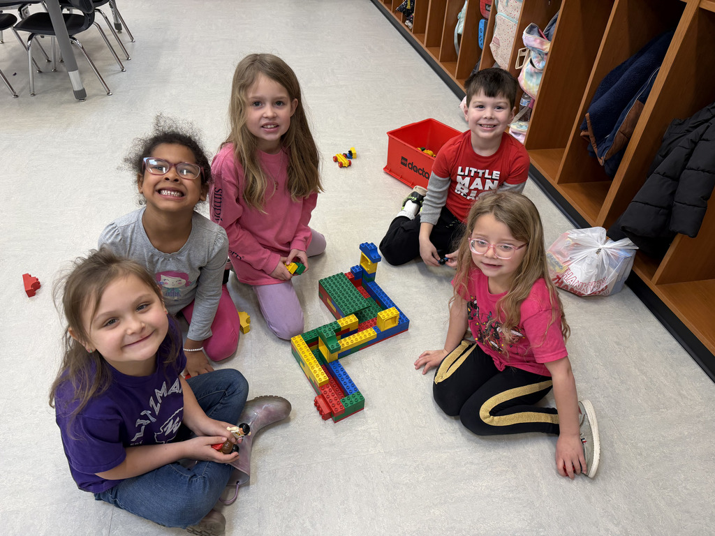 Elementary students posing next to their LEGO build.