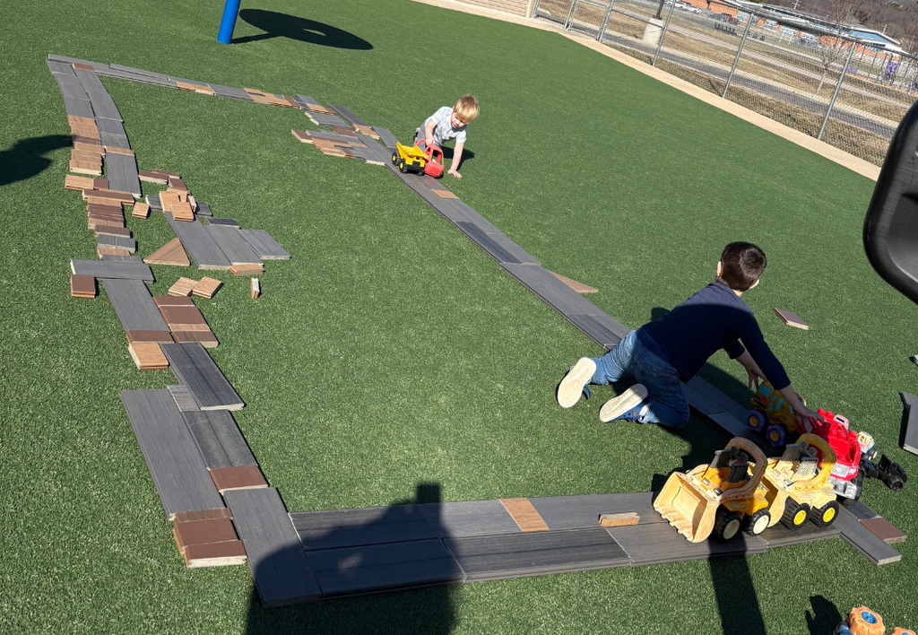 Students outside playing with a fake roadway.