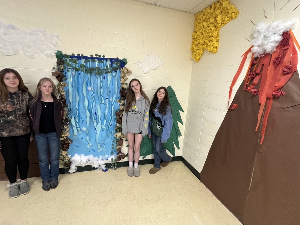 Four students standing next to their water themed wall art.