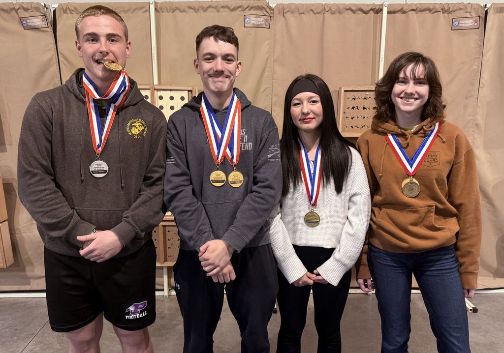Four students standing together with their medals around their necks.