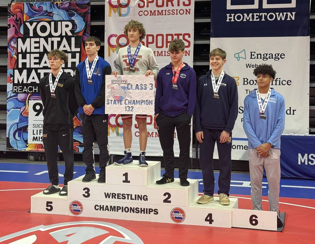 Boys wrestling champs on podium.