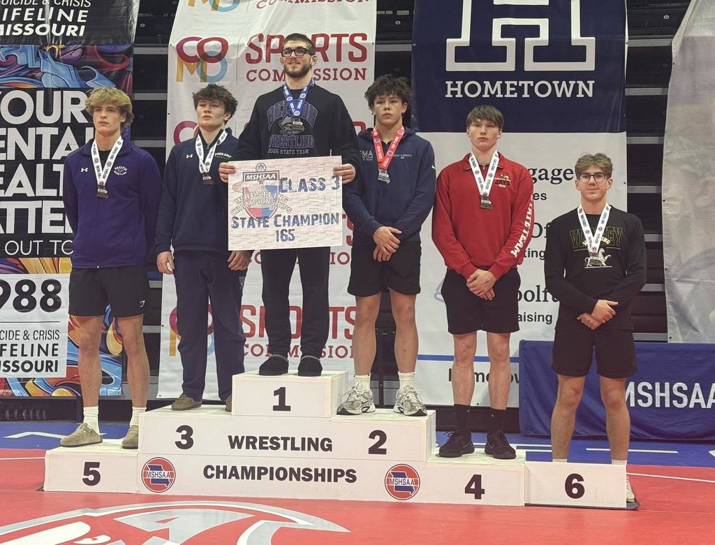Boys wrestling champs on podium.