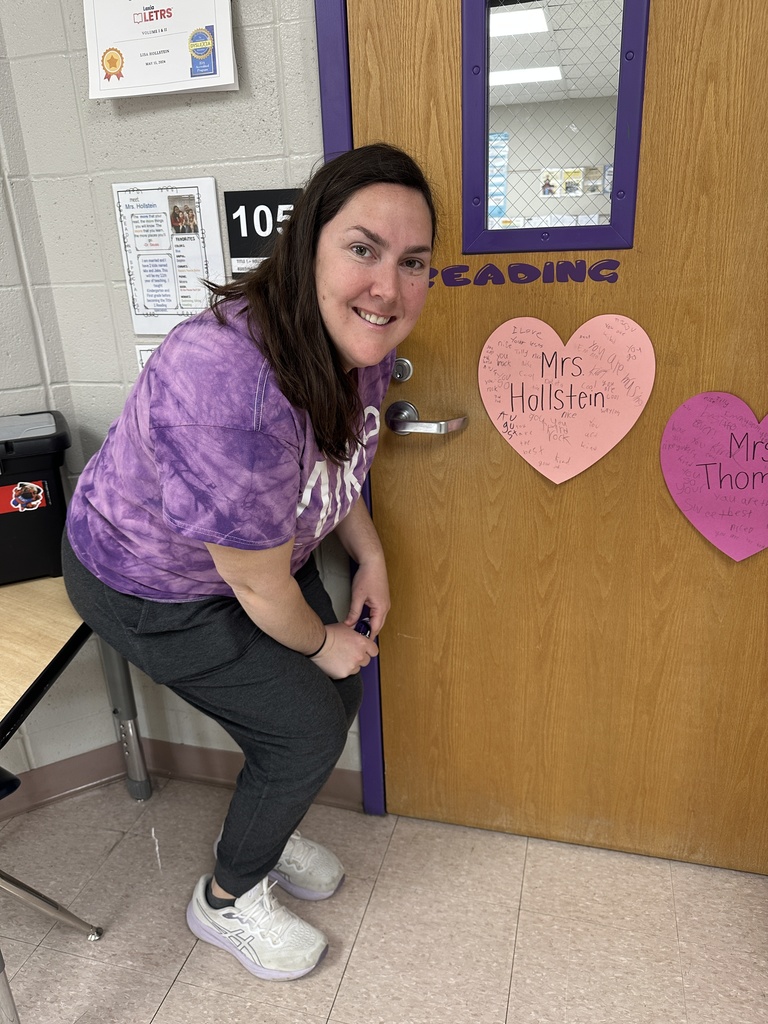 Teacher posing with her heart-shaped paper message from students.