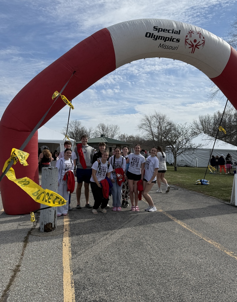 Students posing under a Special Olympics Missouri blow up piece. 
