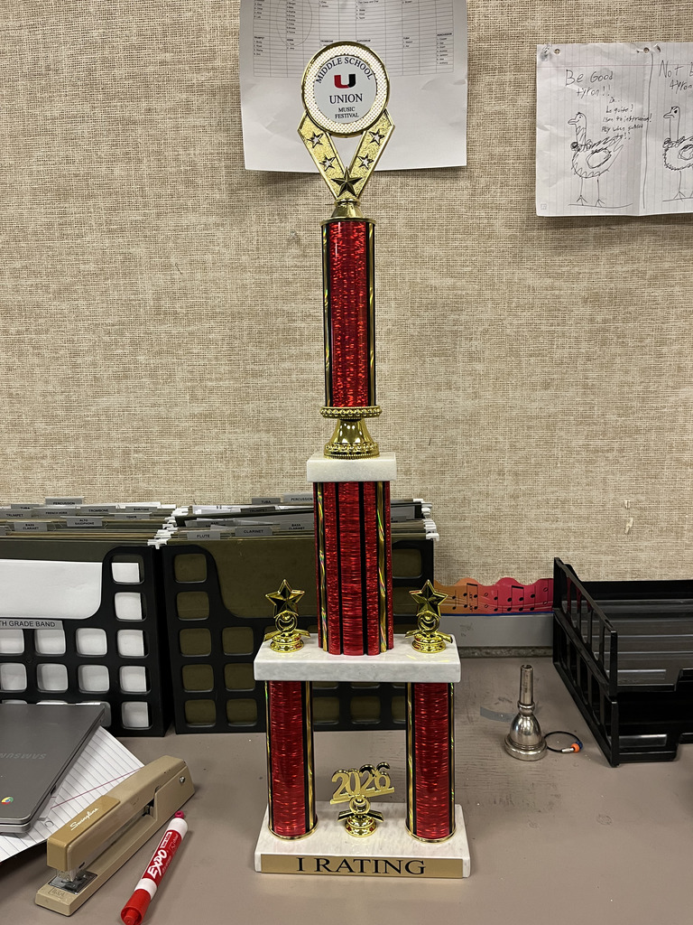 Tall, red trophy with two gold stars sitting on a table.