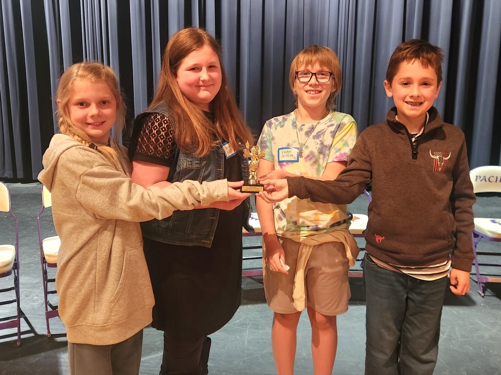 Group of students all holding one gold trophy.