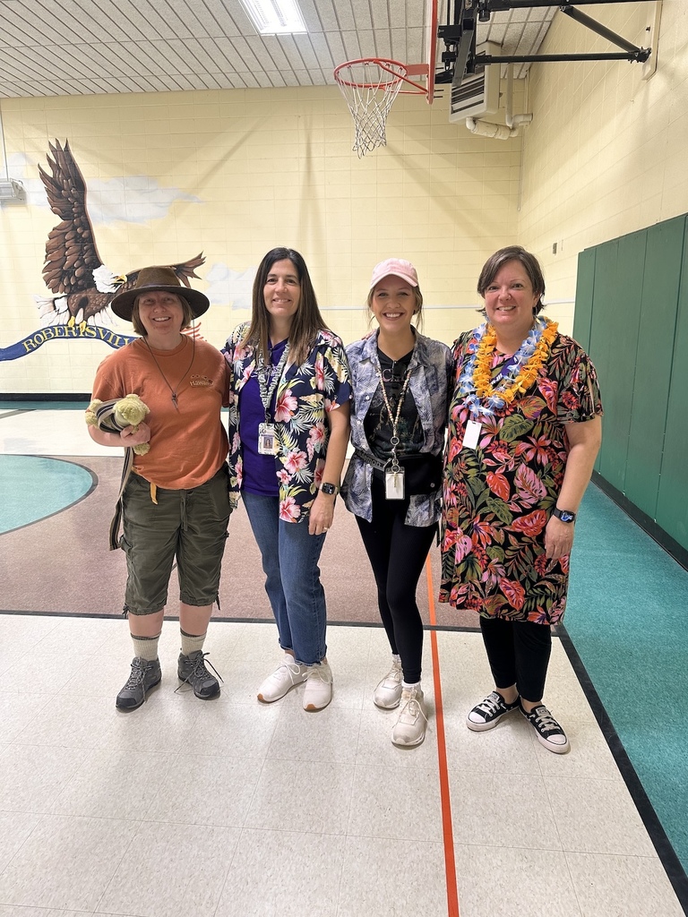 Group of staff members wear colorful, Hawaiian-themed outfits.