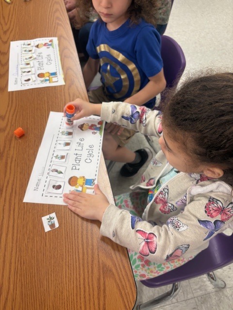 Student using stick glue on a paper project.