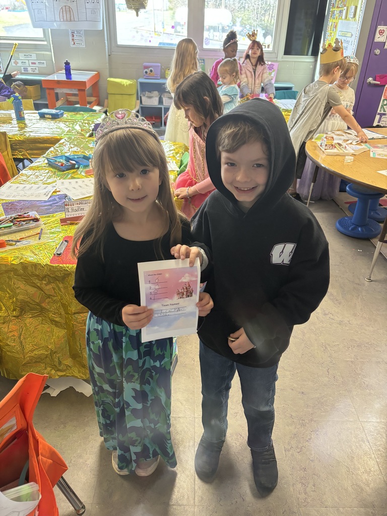 Two students holding paper artwork.