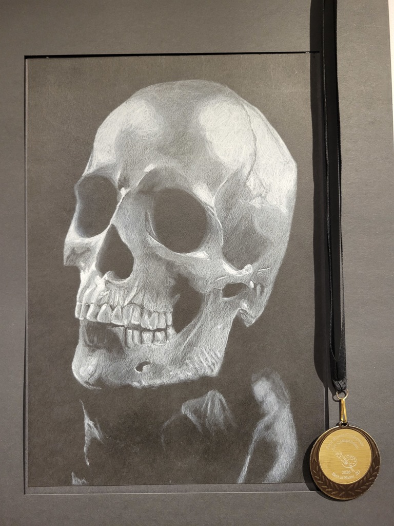 A piece of art showing a skull drawing with a medal attached to it.