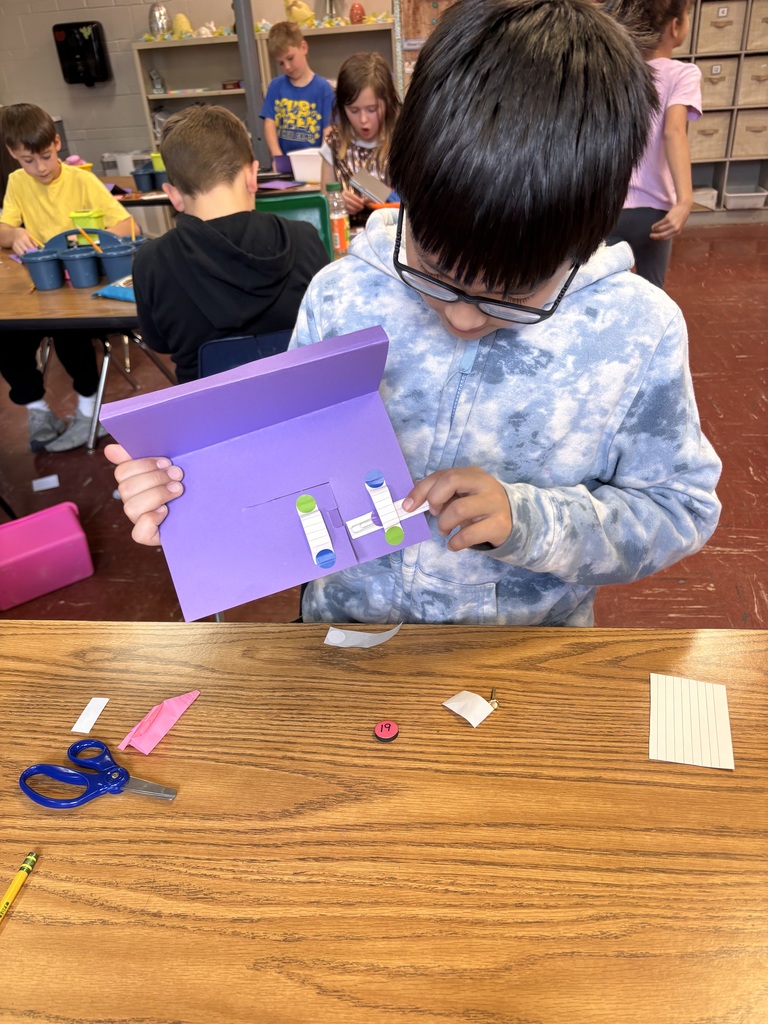 Student working on an assignment in a classroom with purple paper.