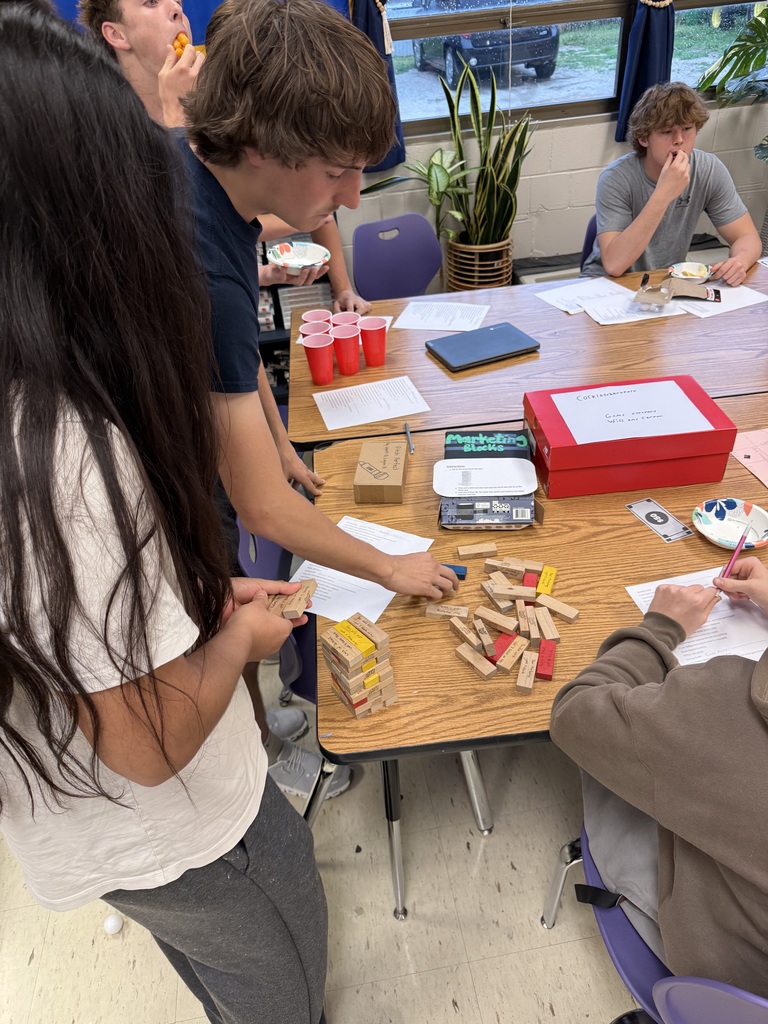 Students playing a game with wooden blocks in a school classroom.