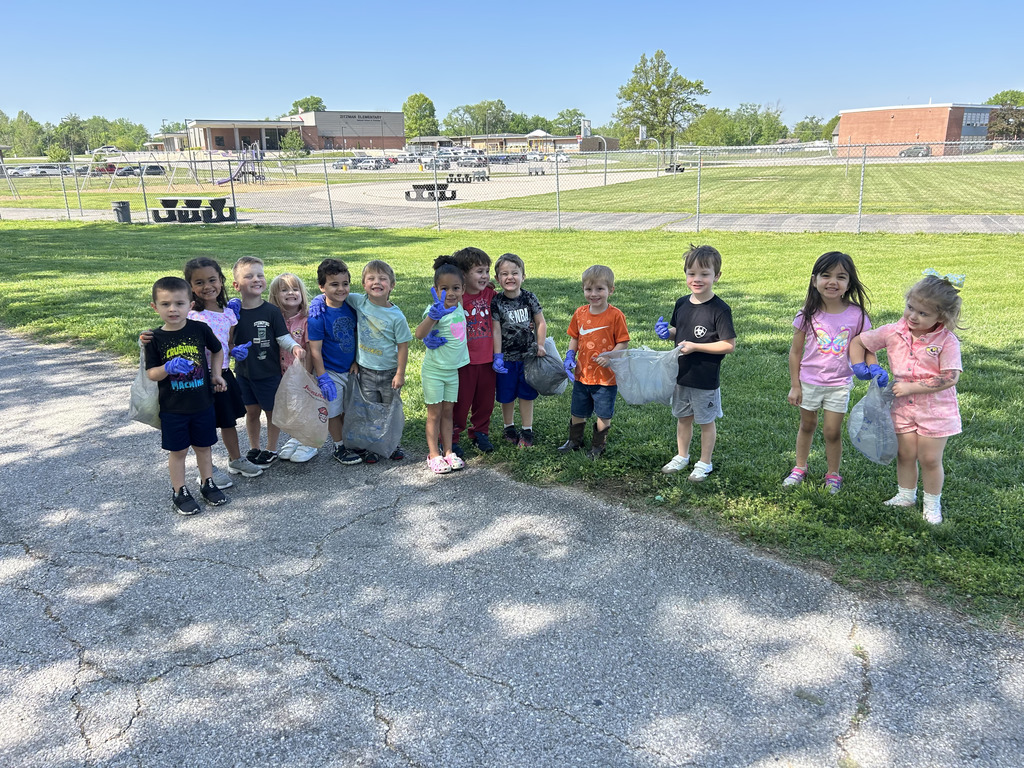 Group of young students posing for a photo outside while holding grocery bags.