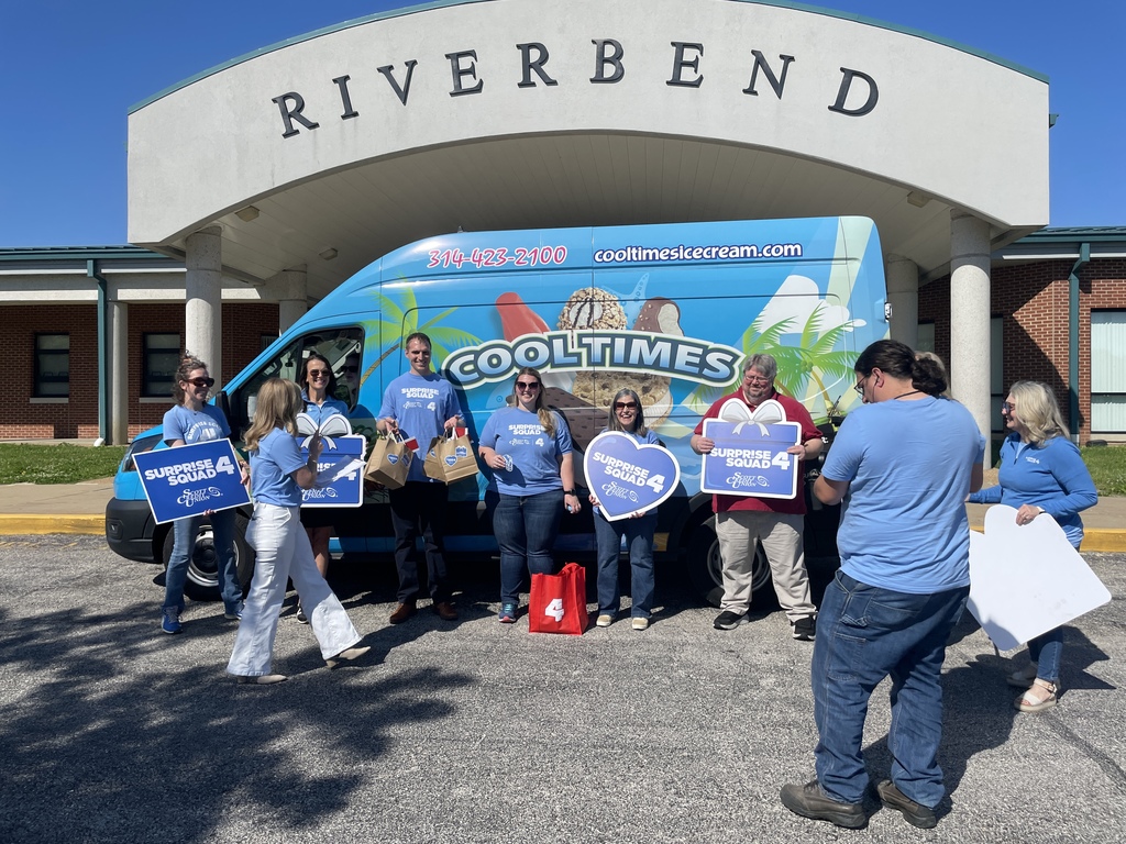 Adults stand in front of a blue ice cream truck in front of the "Riverbend" school signage. 
