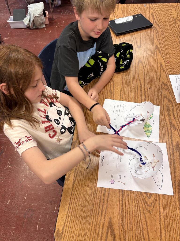 Two students work together at a desk.