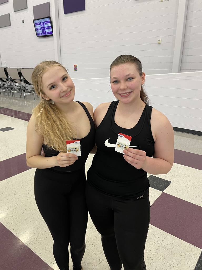 Two students pose for a photo holding two small certificates.