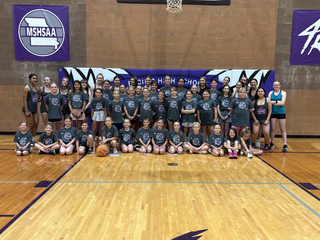Large group of girls basketball campers and older student mentors gather for a team photo in the Pacific High School gym.