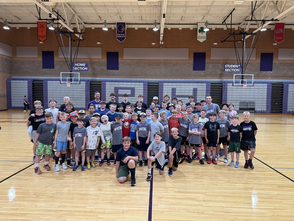 Dozens of young basketball campers and coaches gather for a group photo on the Pacific High School gym court, smiling after camp activities.