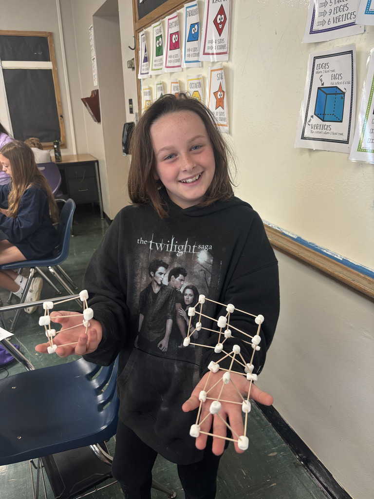 Student holding a 3D model with toothpicks and marshmallows.