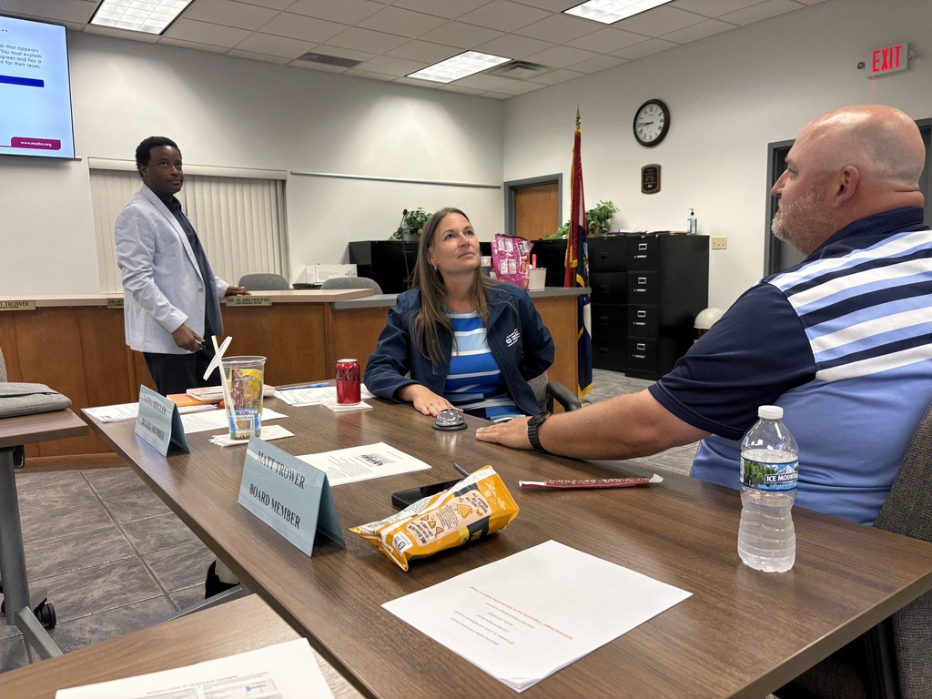 Staff members watching a presentation in a board room.