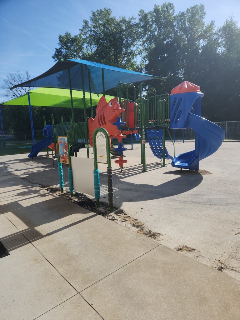 An outdoor playground with a large fish slide.
