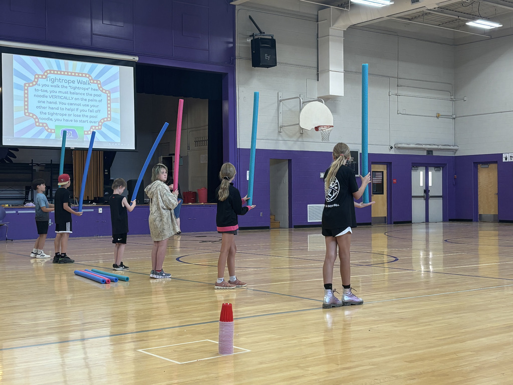 Students playing a game in an indoor school gym.
