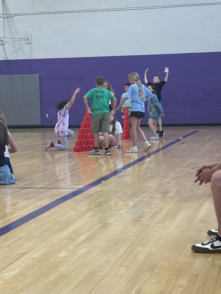Students playing a game in an indoor school gym.