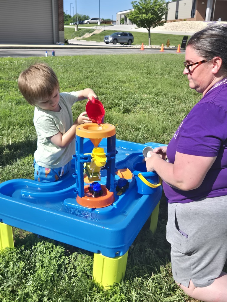 Young students playing in water outdoors.