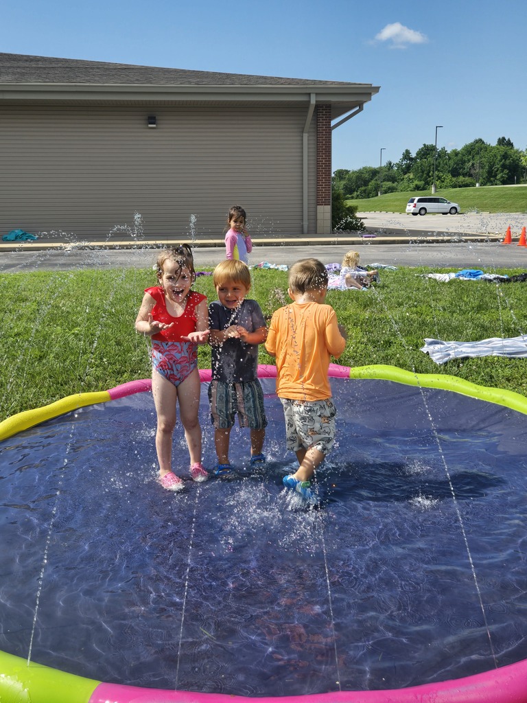 Young students playing in water outdoors.