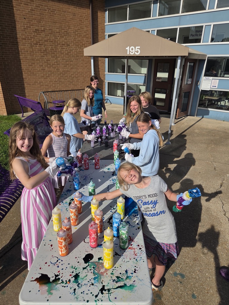 Students making tie-dye t-shirts outdoors.