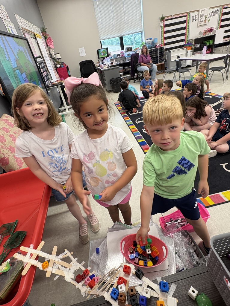 Young students working on a craft project in groups.