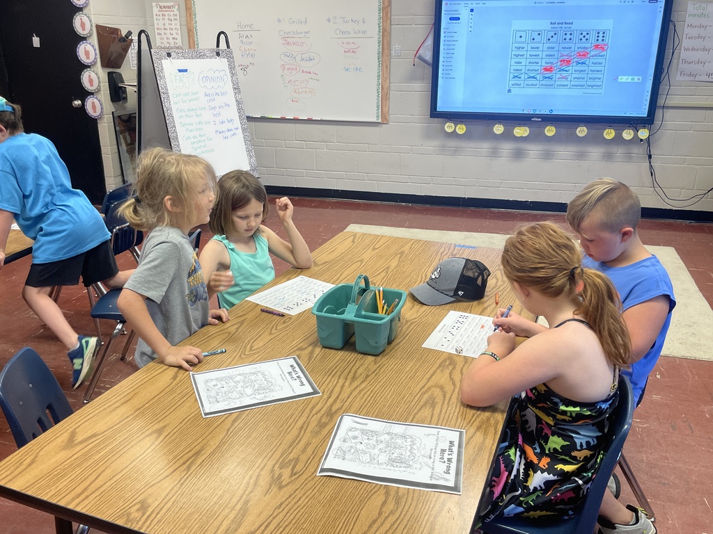 Elementary students practice reading and vocabulary skills through interactive games and group activities during summer learning.