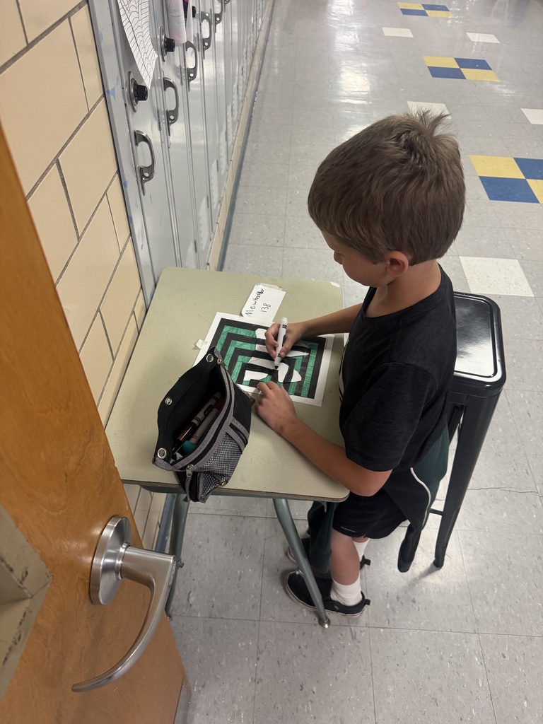 Student colors an optical illusion design while working independently in the hallway.